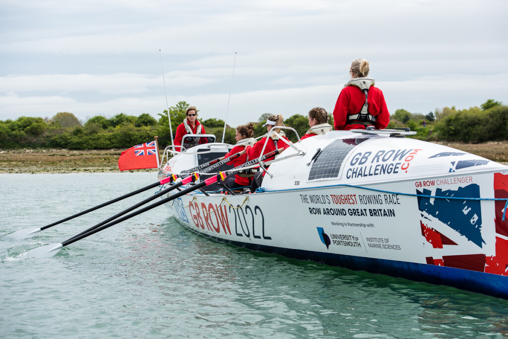 All Systems row out on the water in their sailing boat