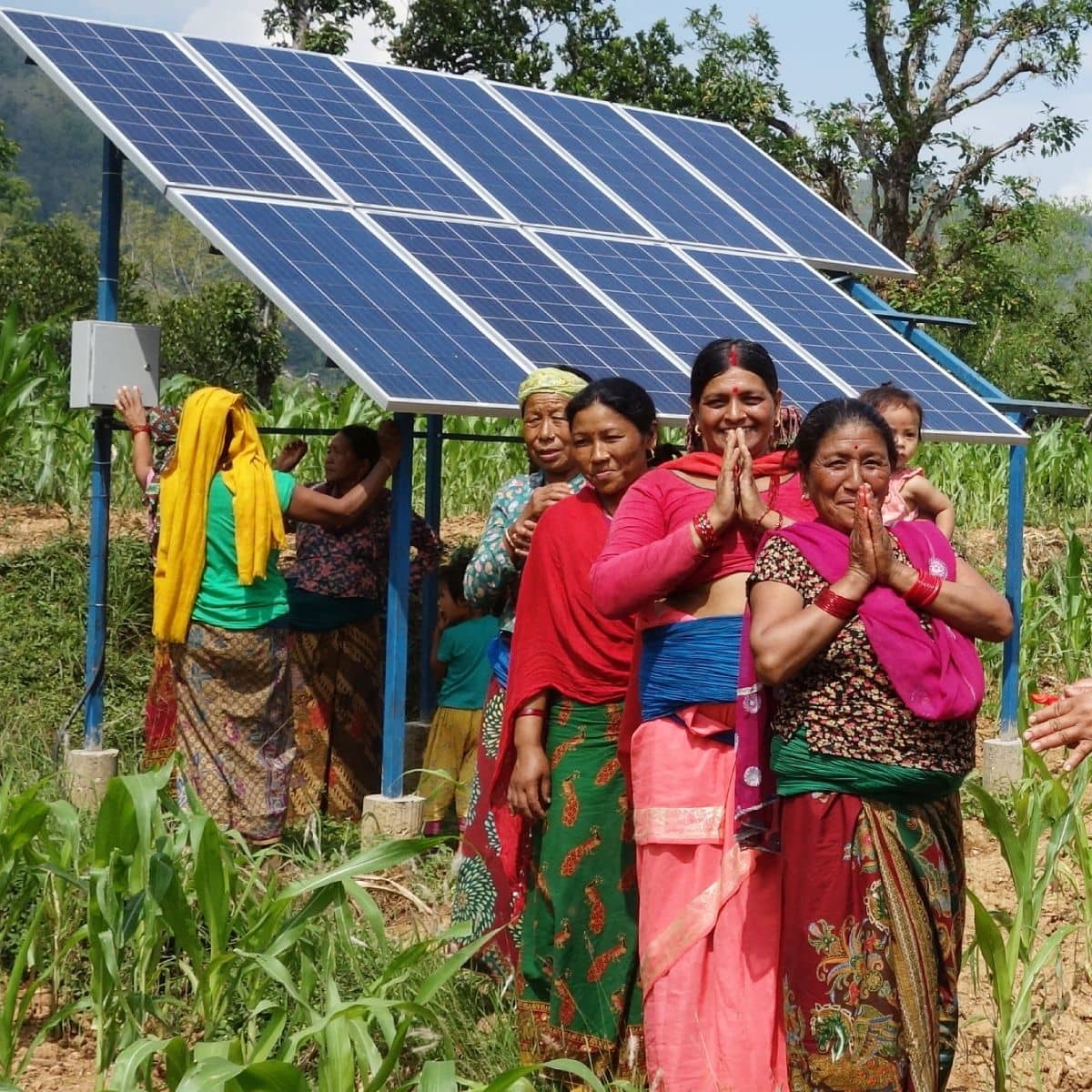 Ladies standing in front of a solar panel.